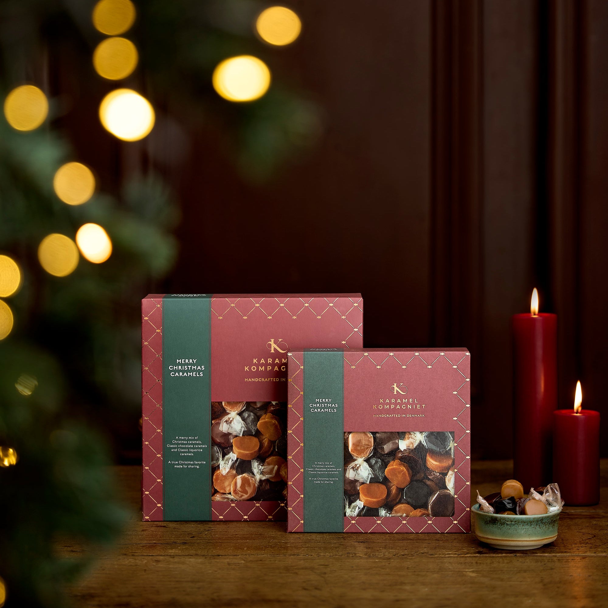 Glædelig Jul julekaramelblanding med flødekarameller, lakridskarameller og chokoladekarameller i en oprejst Q2 og Q3 juleæske fra Karamel Kompagniet med en skål karameller ved siden af