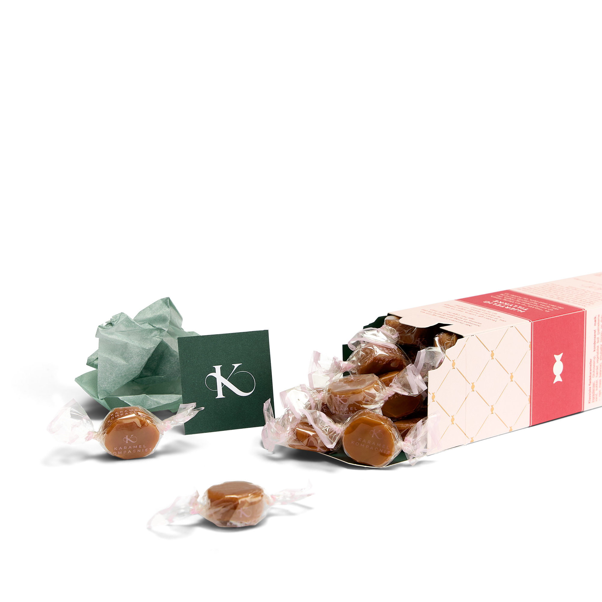 Klassiske flødekarameller i en hjerteligt tillykke-æske der ligger ned med karameller der flyder ud