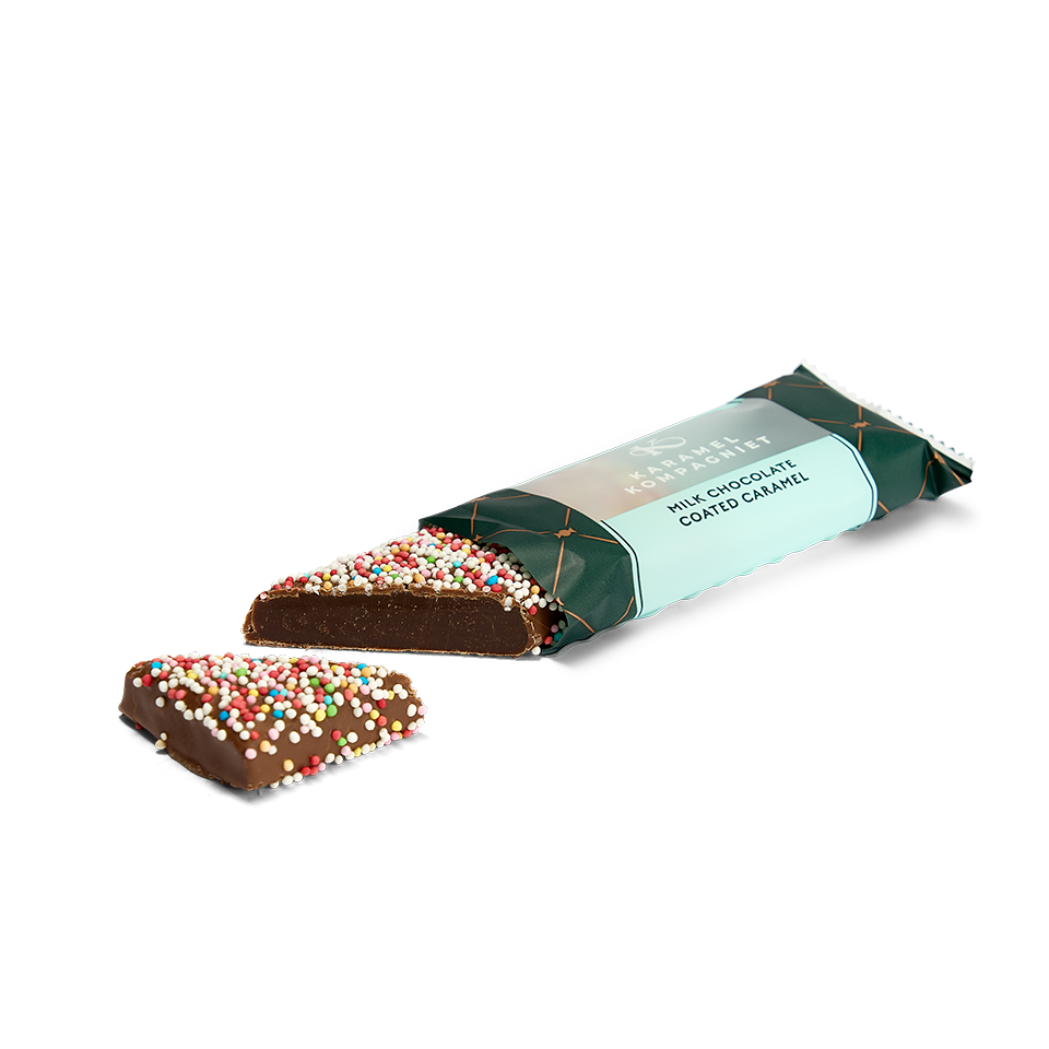 Karamel Bar Romkugle skåret over – blød karamelkerne overtrukket med mælkechokolade og farverige nonpareils